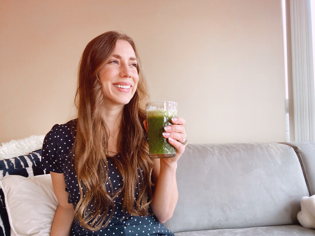 Woman drinking a green celery juice 